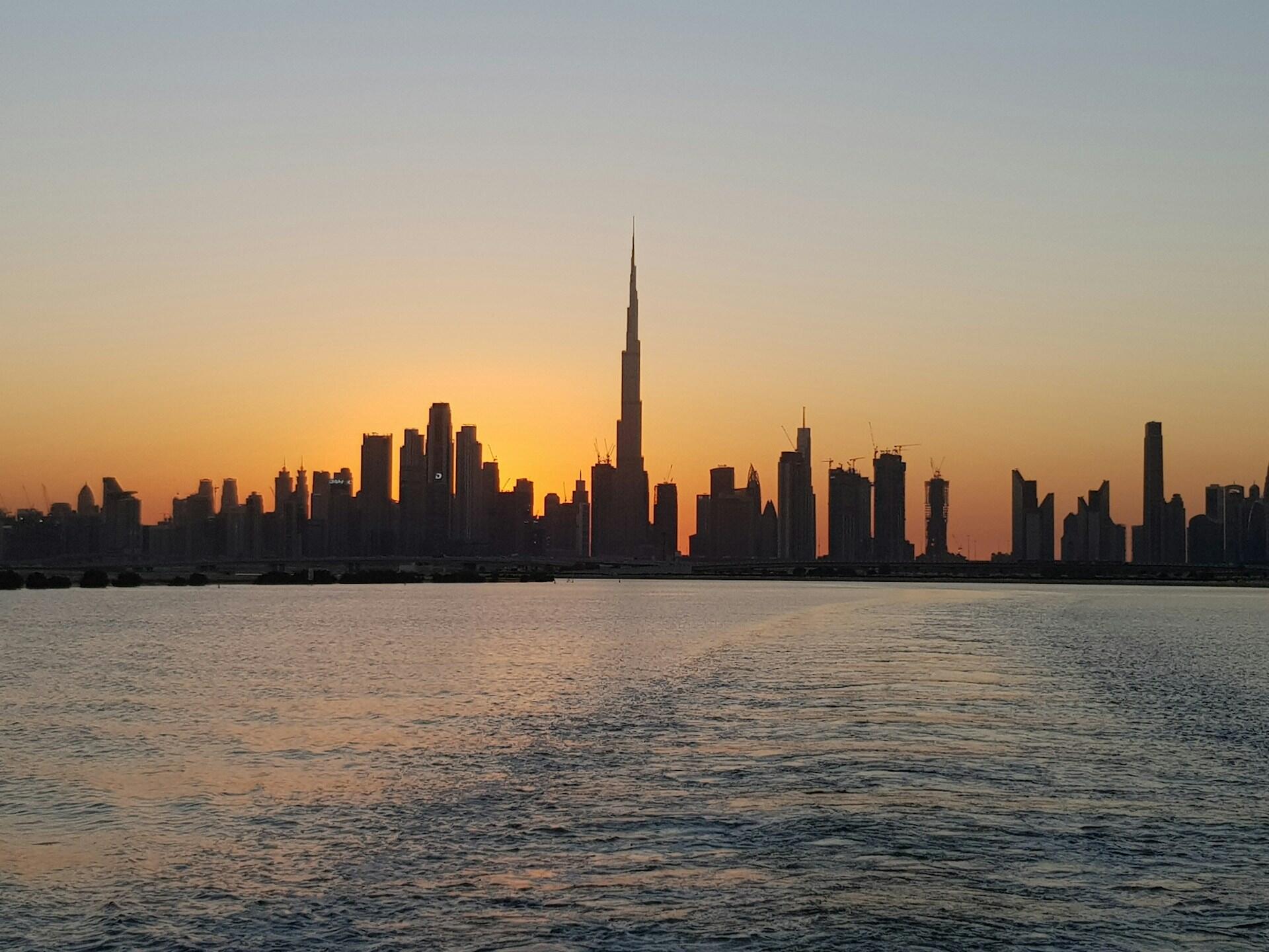 modern dubai skyline at sunset across water reflecting the transformation in the history of uae