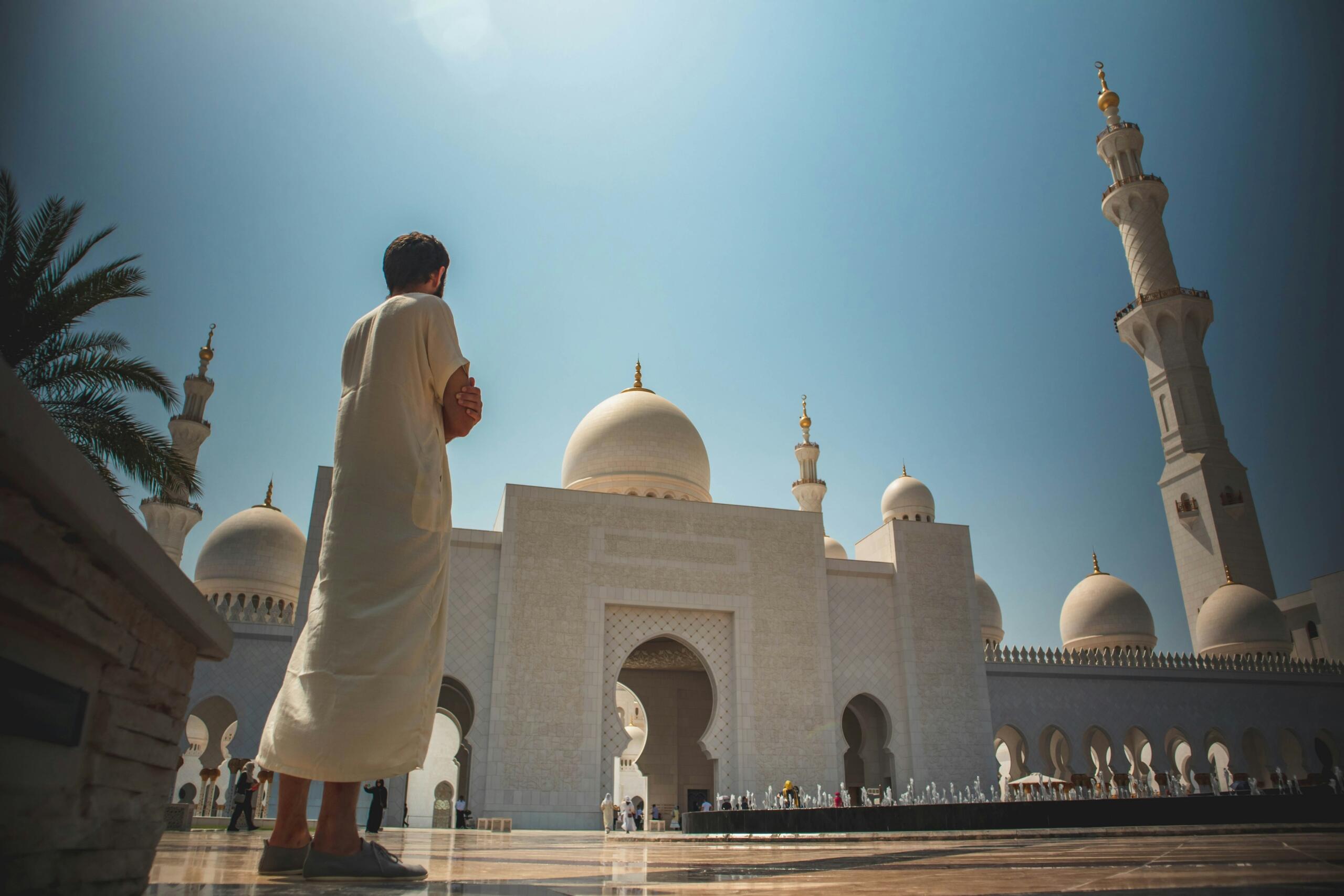 A man in traditional attire stands before Sheikh Zayed Grand Mosque in Abu Dhabi during the Islamic New Year holiday in the UAE