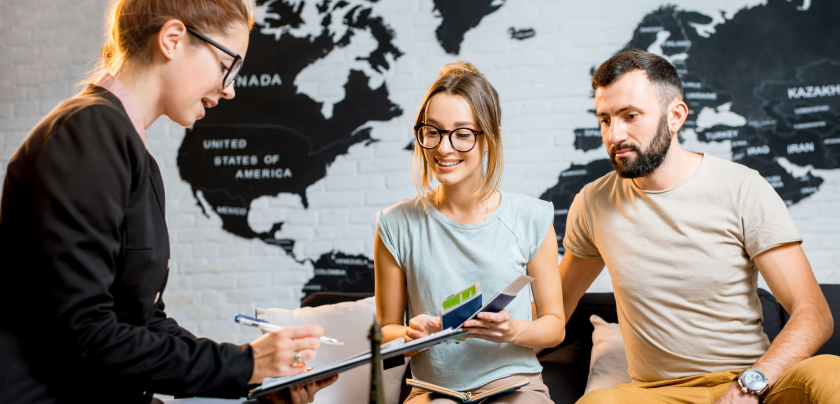 Two expats consulting an advisor about English language school Dubai options in front of a world map