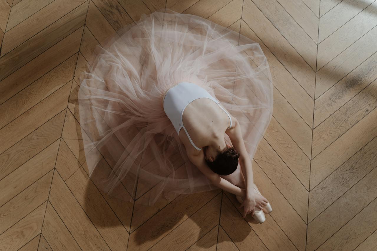 Mujer bailarina elongando en el suelo.