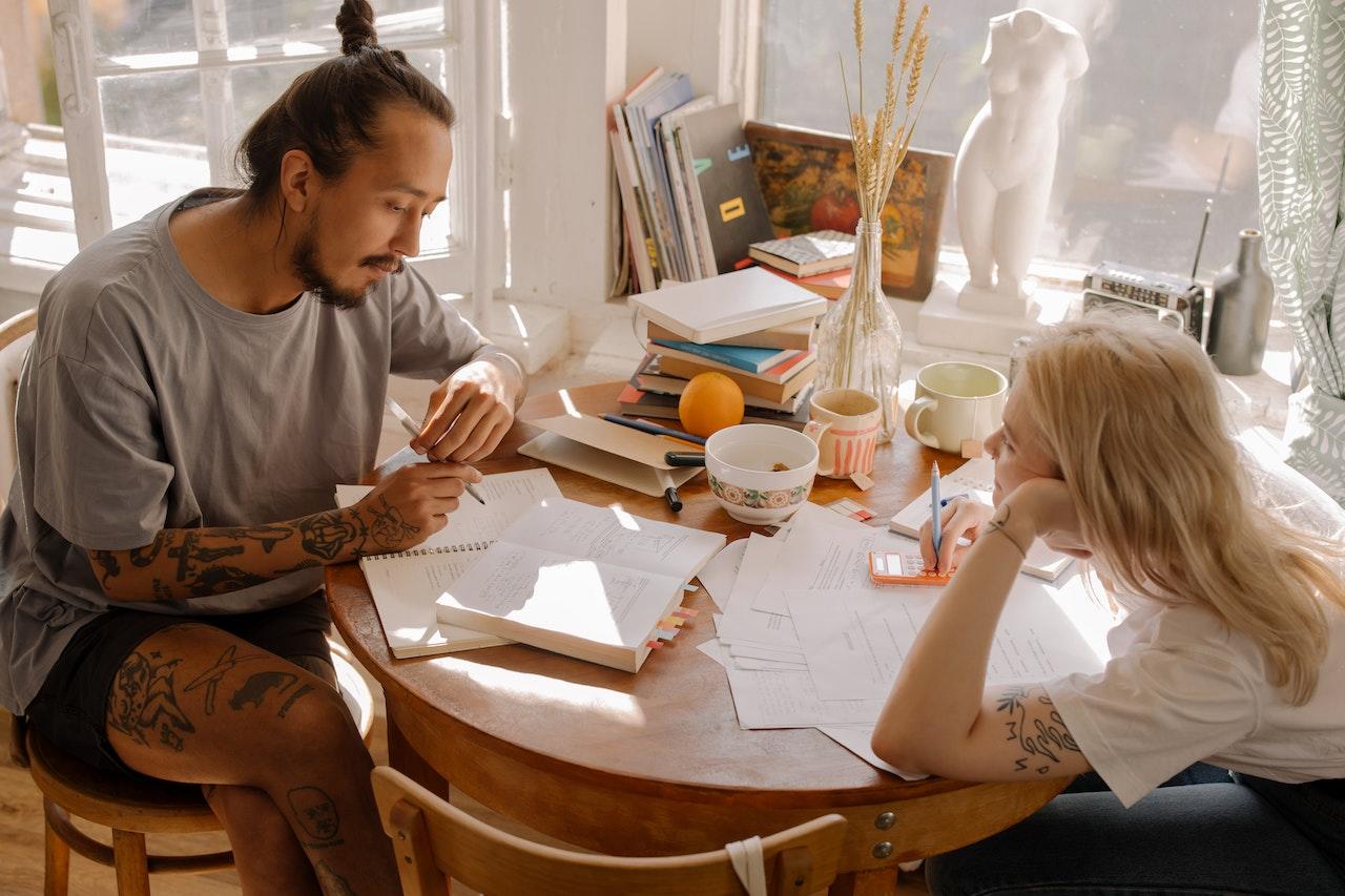 Dos personas en una mesa, sentados estudiando