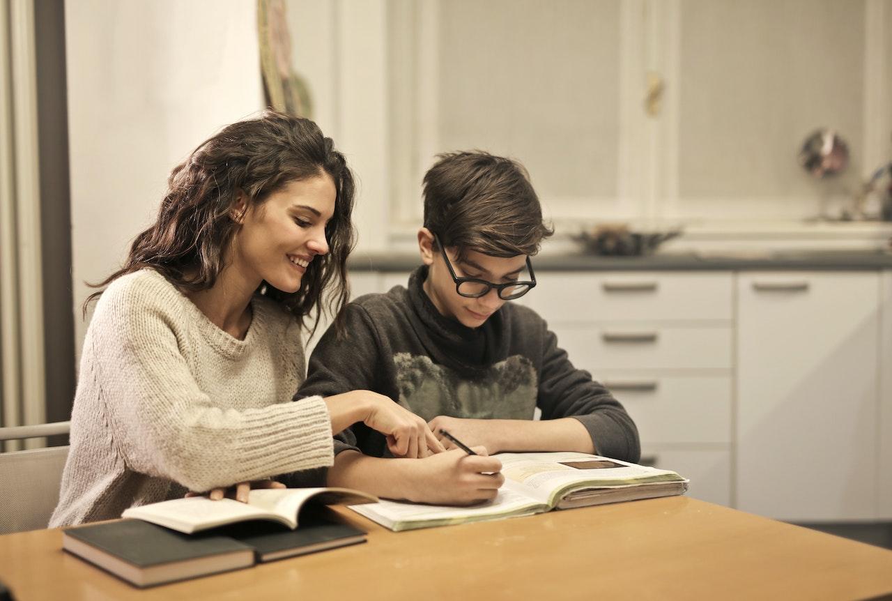 Maestra particular enseñando a un niño en su casa.