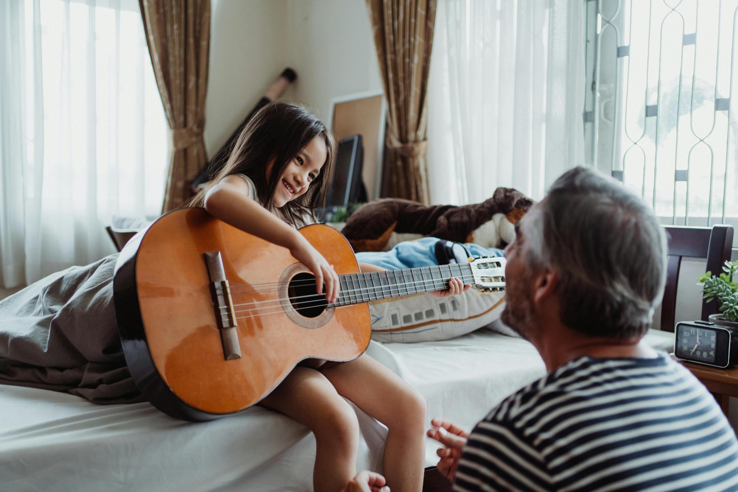 padre e hija tocando la guitarra
