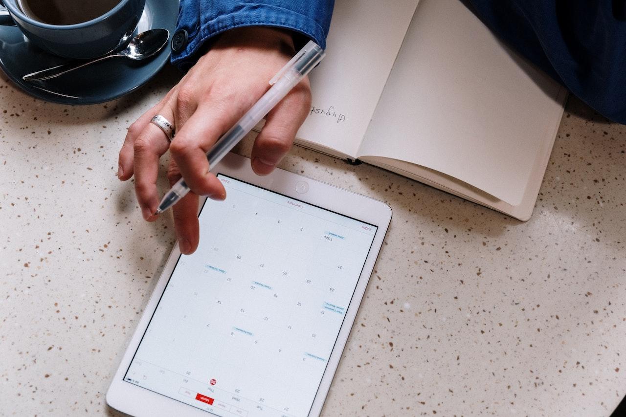 Persona organizandose con la tablet y papeles.