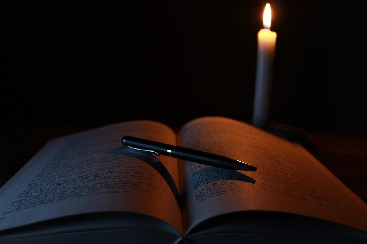 Libro junto a una vela prendida