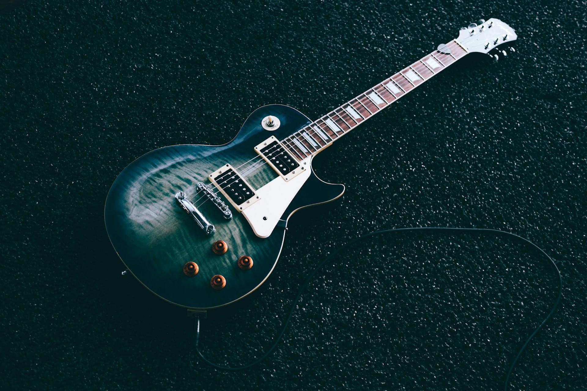 Foto de guitarra eléctrica sobre fondo verde.