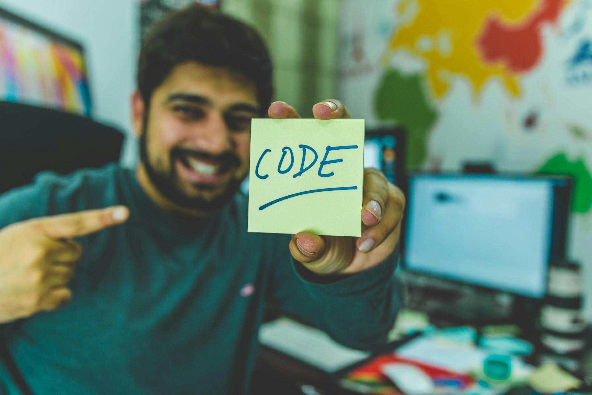 Persona mostrando un cartel con la palabra "code".