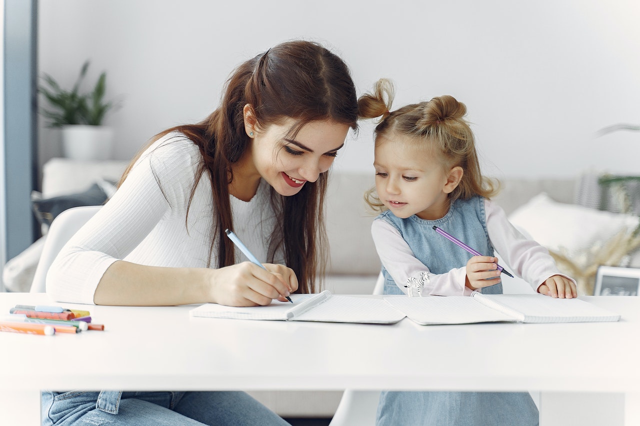 Mujer y niña haciendo los deberes juntas
