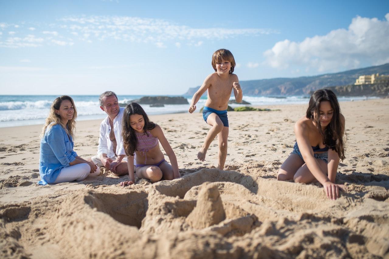 Familia jugando en la arena de la playa