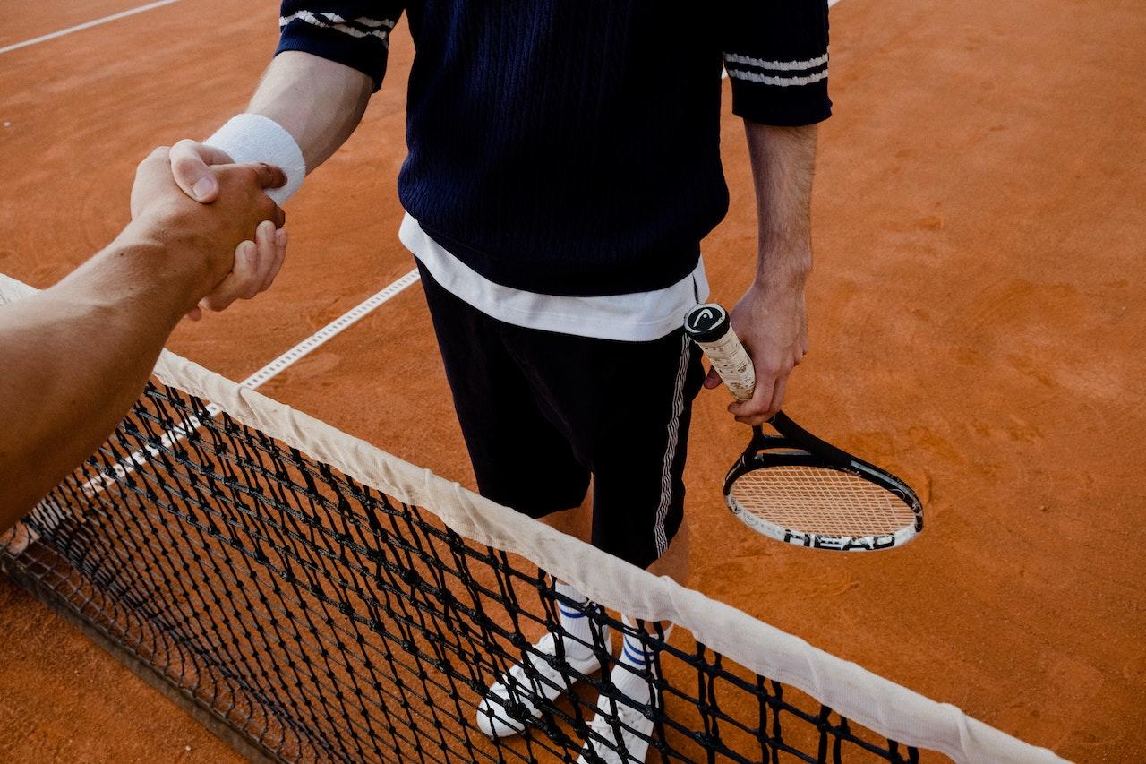Jugadores de tenis, dándose la mano en la cancha