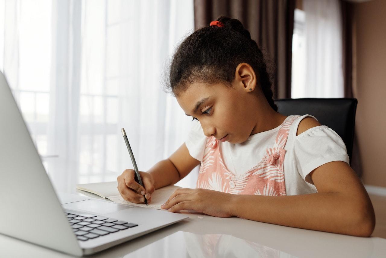 Niña estudiando con el ordenador.
