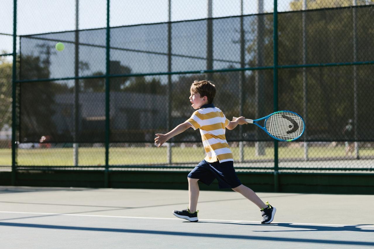 Niño jugando al tenis