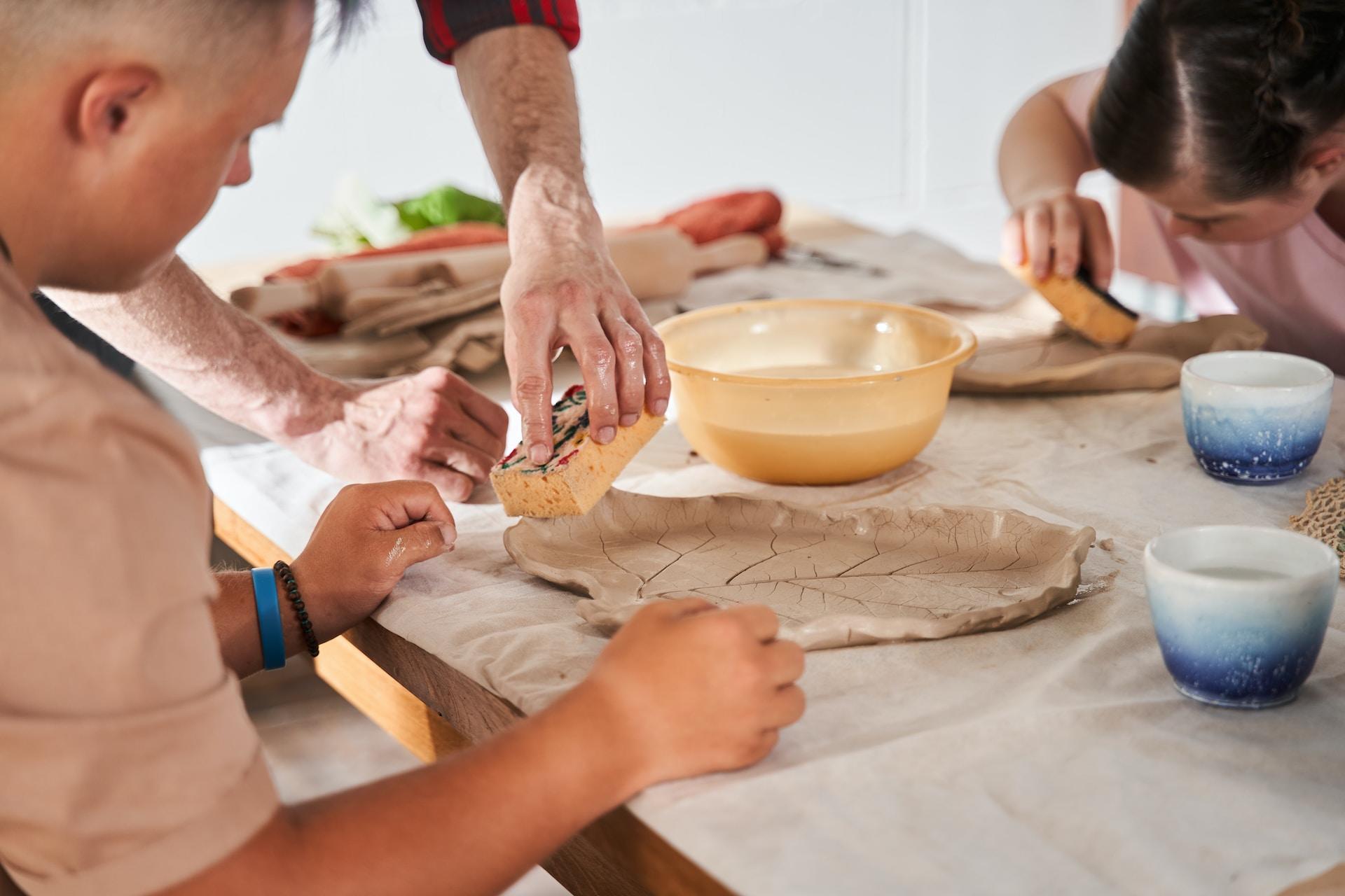 Personas haciendo cerámica en mesa