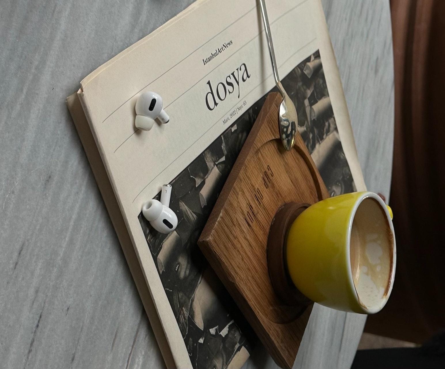 Periódico, auriculares taza de cafe.