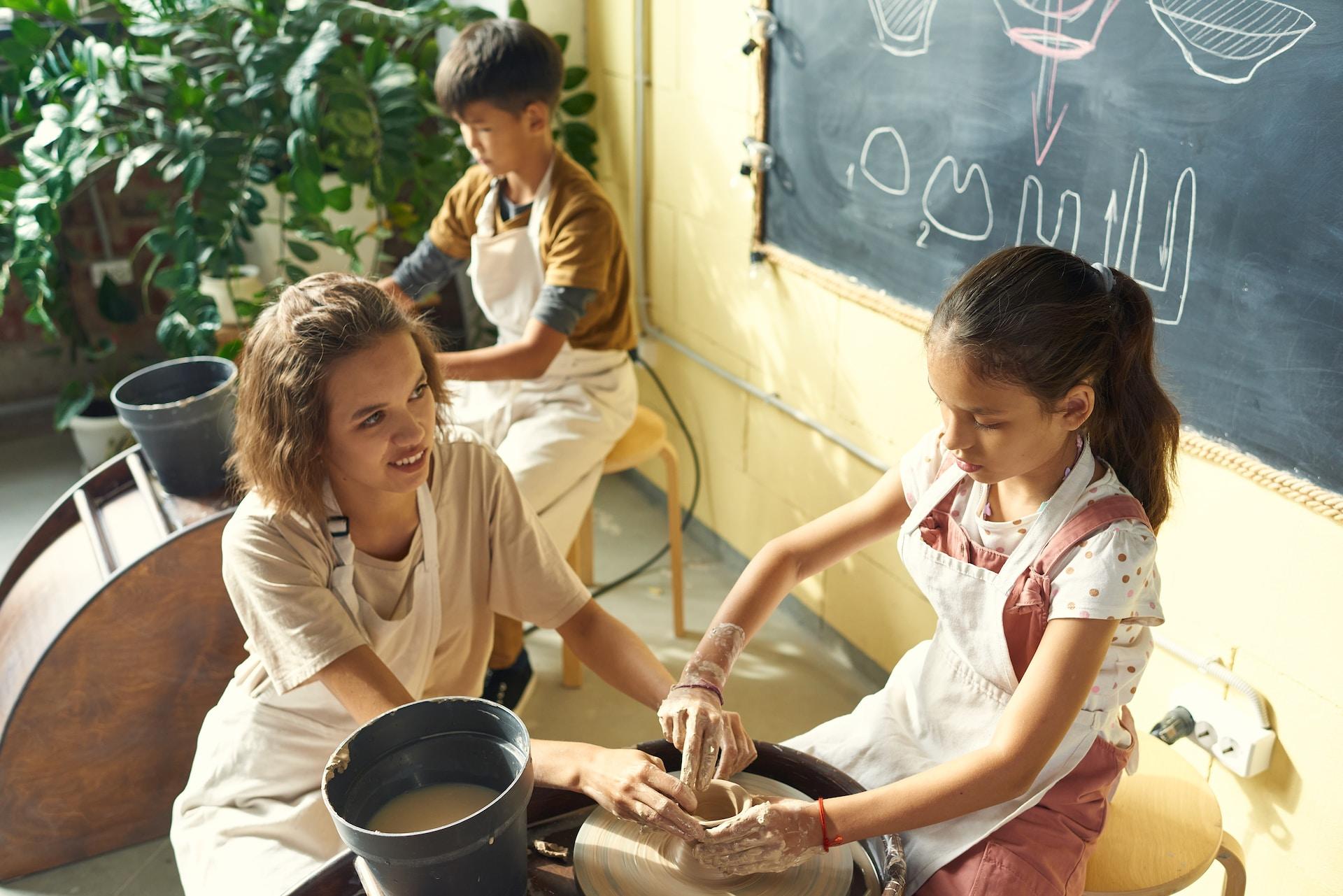 Clase de cerámica, profesora y dos niños.