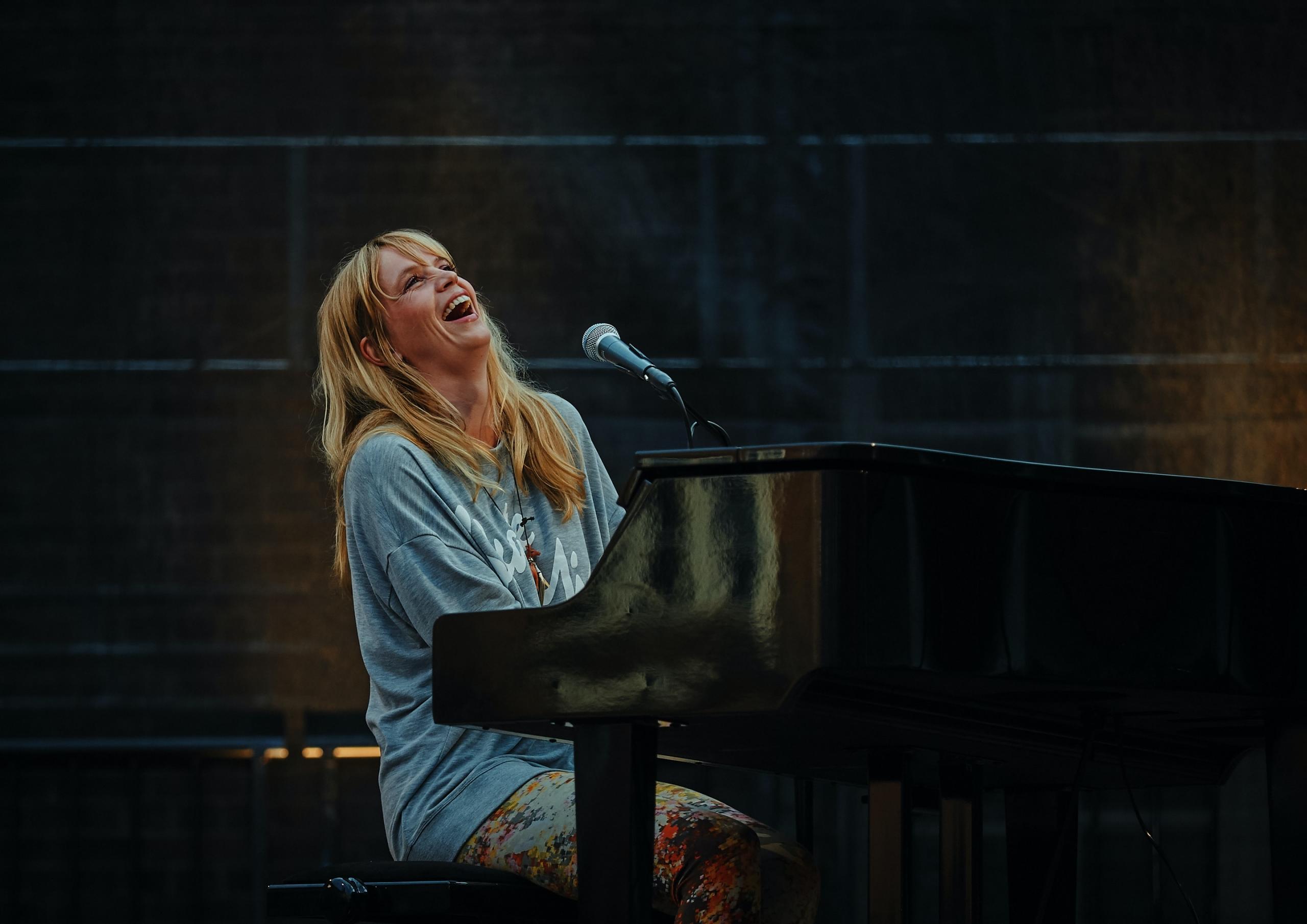 Mujer tocando el piano en un concierto.