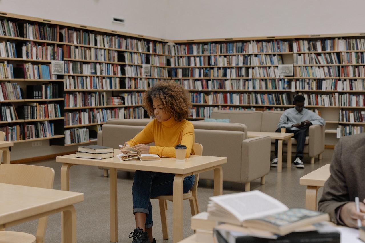 Mujer leyendo en una biblioteca