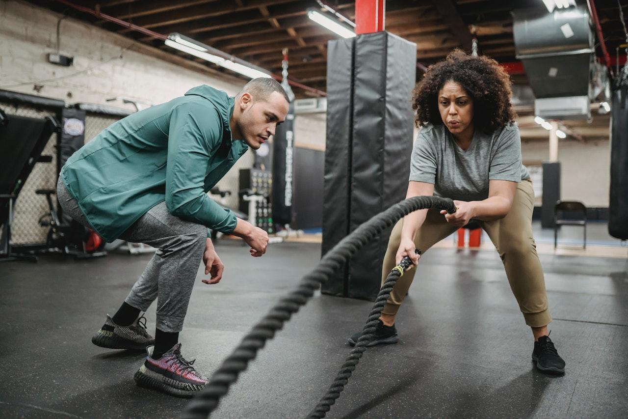 Mujer entrenando en el gimnasio con entrenador