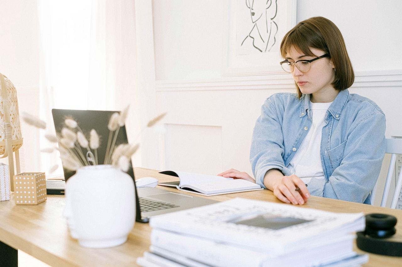 Mujer sentada en el escritorio trabajando con la computadora.