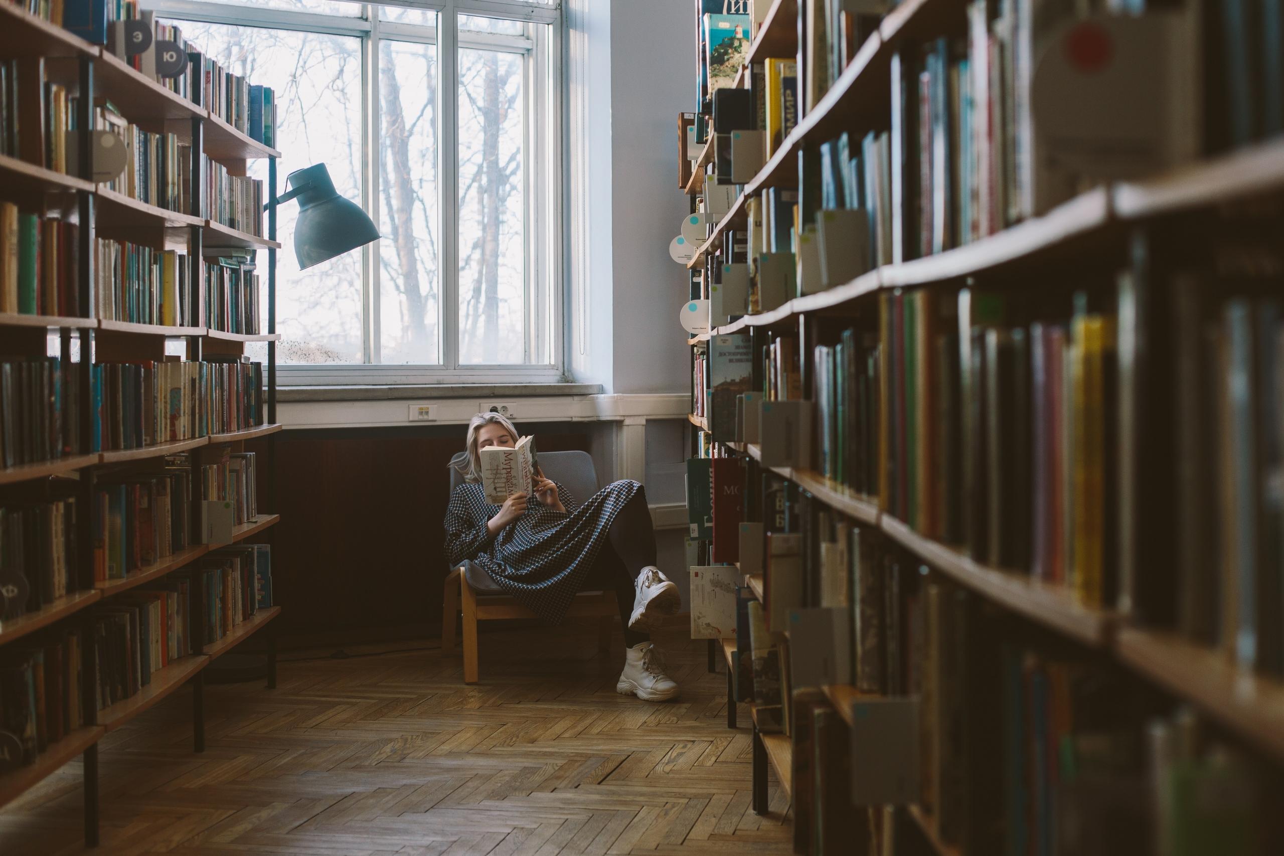 Mujer en una biblioteca leyendo