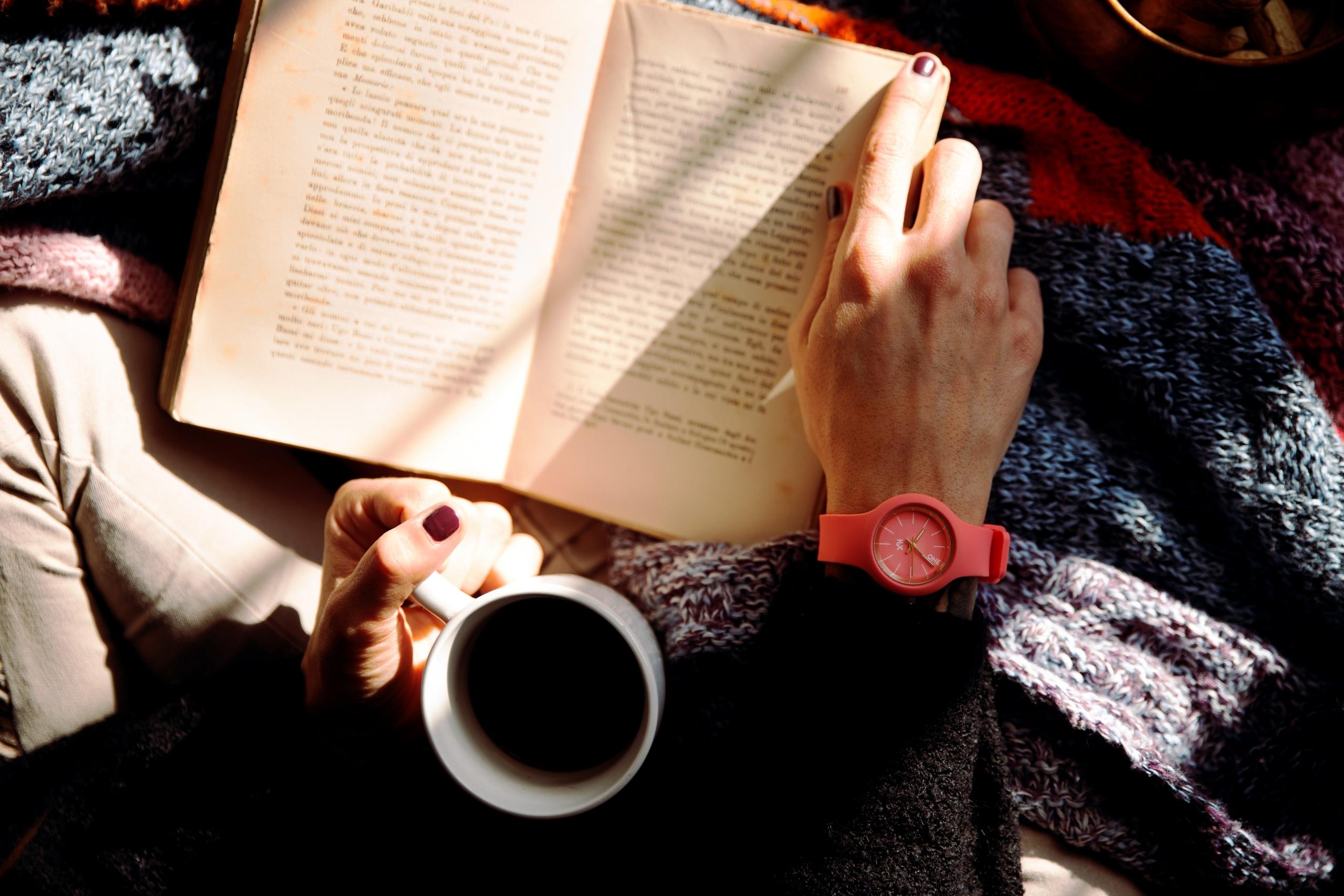 persona leyendo con un café en la mano