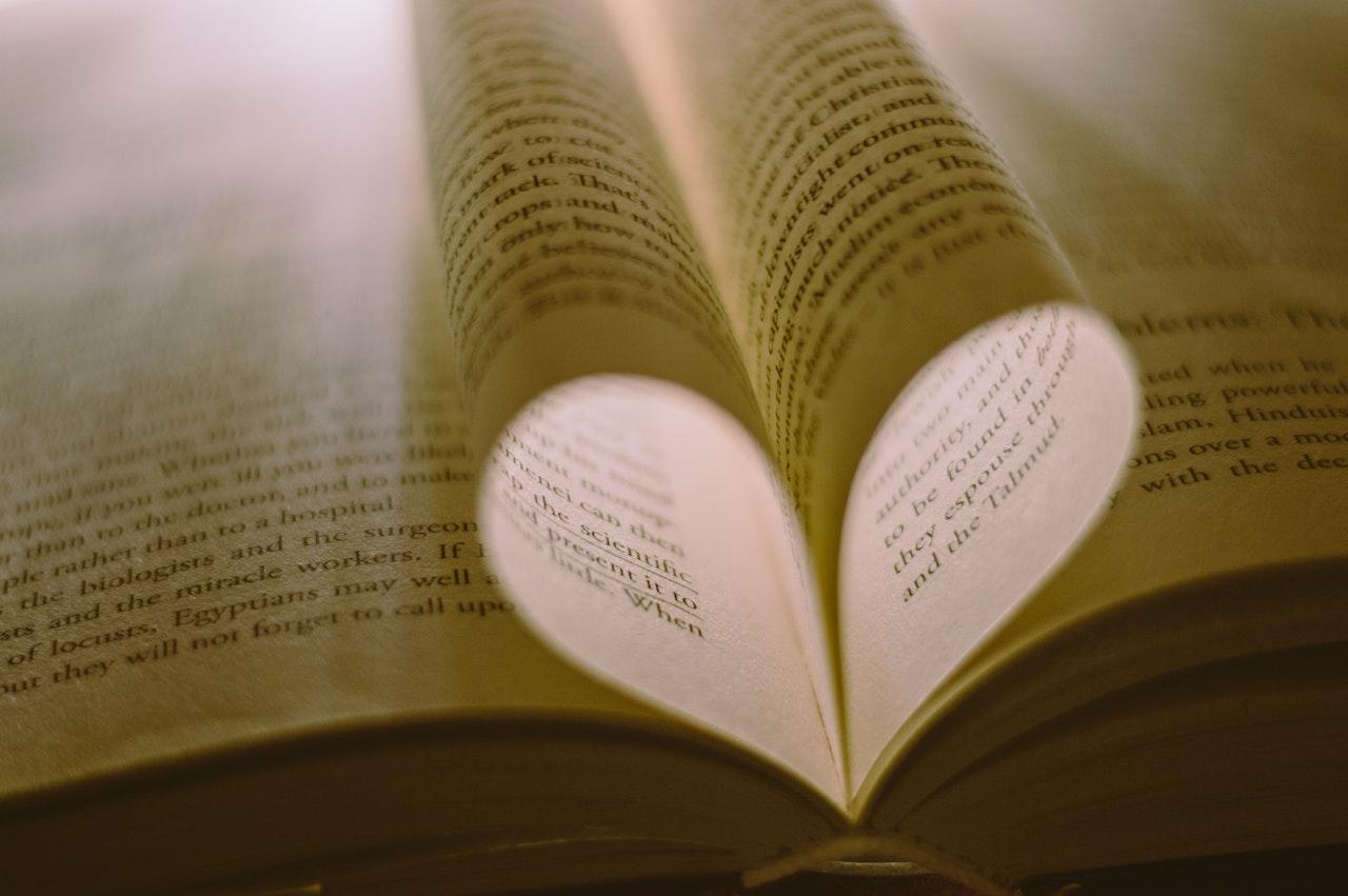 Hojas de un libro que se unen en forma de corazon.