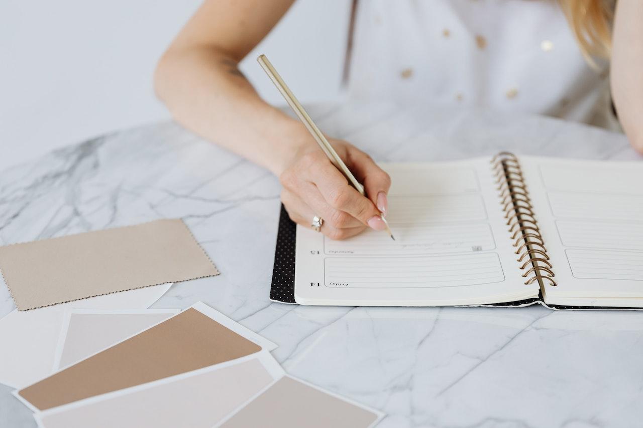 Persona escribiendo en una agenda.