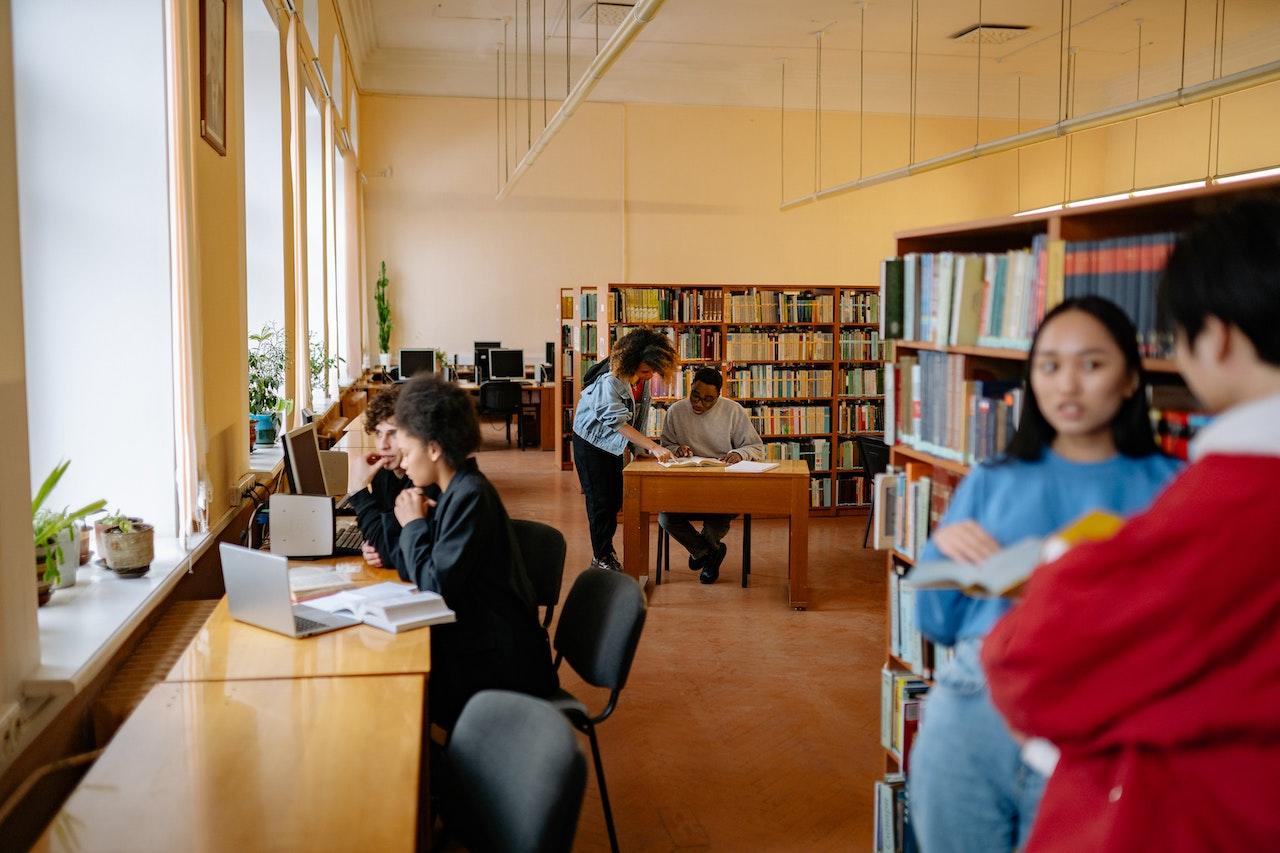 Gente leyendo en la biblioteca.