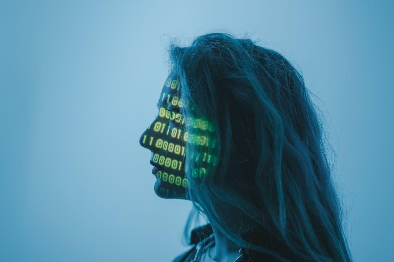 Mujer de perfil con un código reflejado en su rostro.