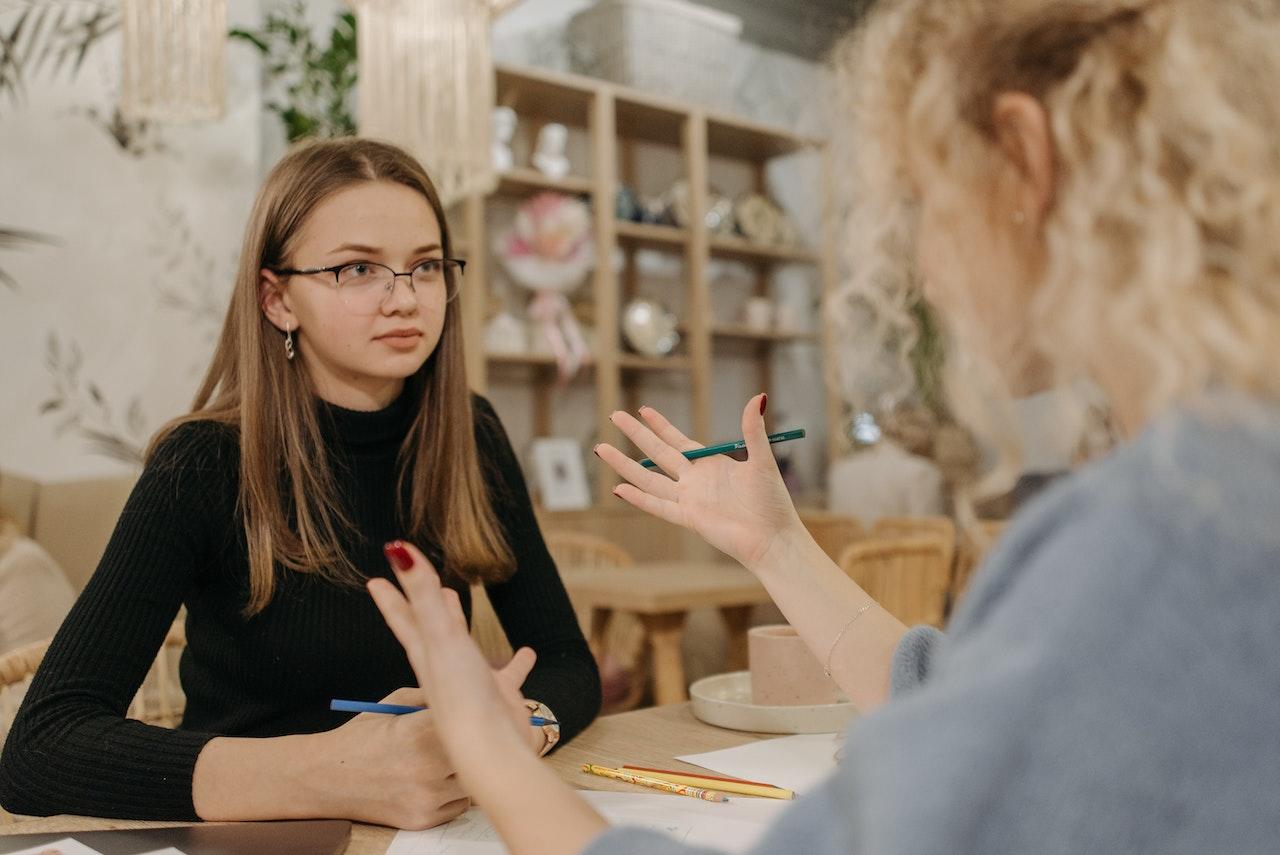 Dos mujeres hablando y moviendo las manos.