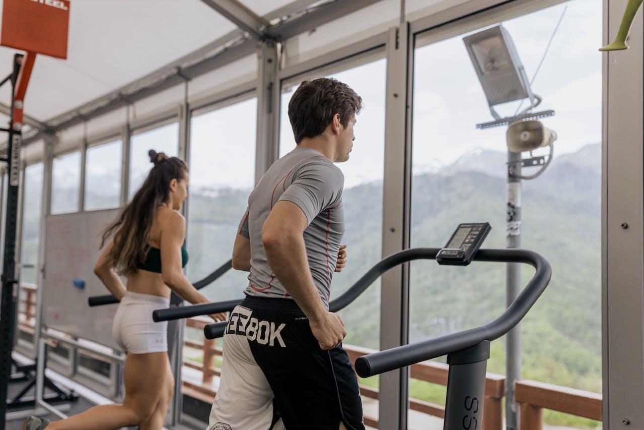 Dos personas haciendo ejercicio en la cinta de correr. 
