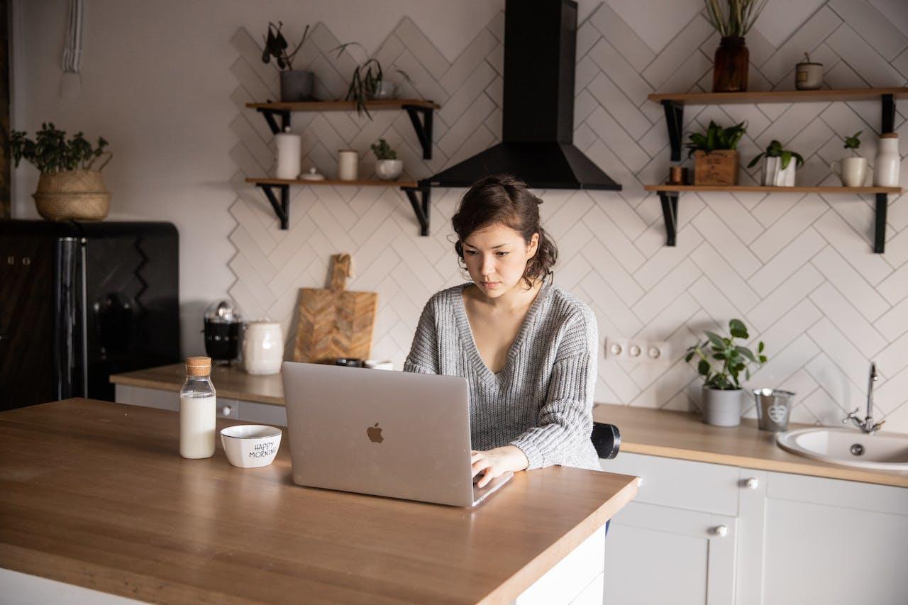 Mujer en la cocina con computadora