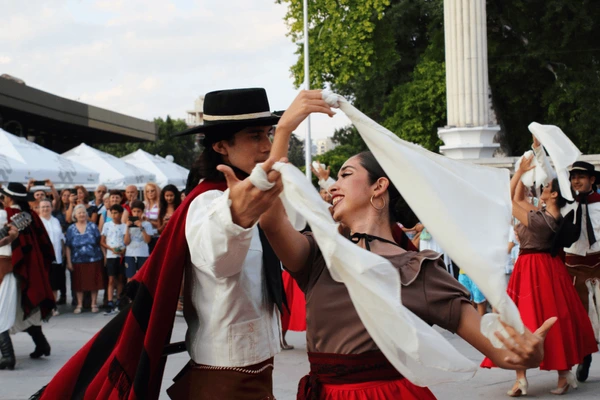 Un hombre y una mujer bailando con pañuelos blancos.