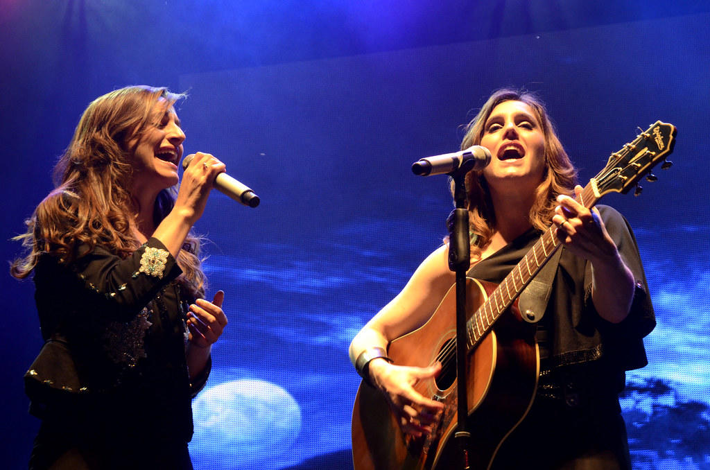 Dos mujeres cantando y tocando la guitarra.