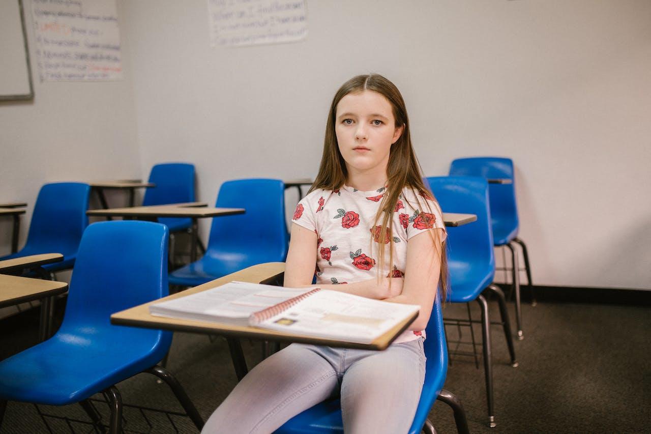 Niña sentada en el aula de la escuela.