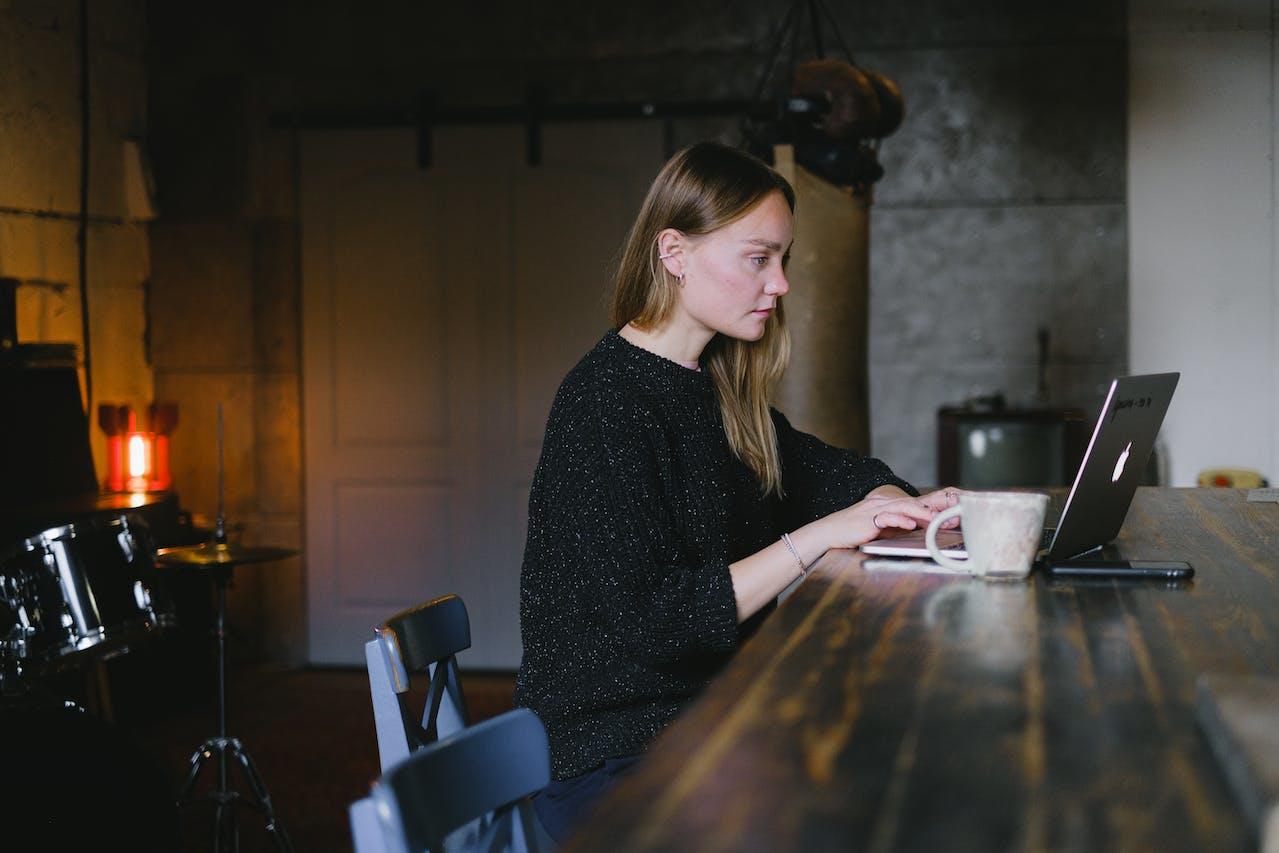 Mujer sentada en la mesa frente a la pc.