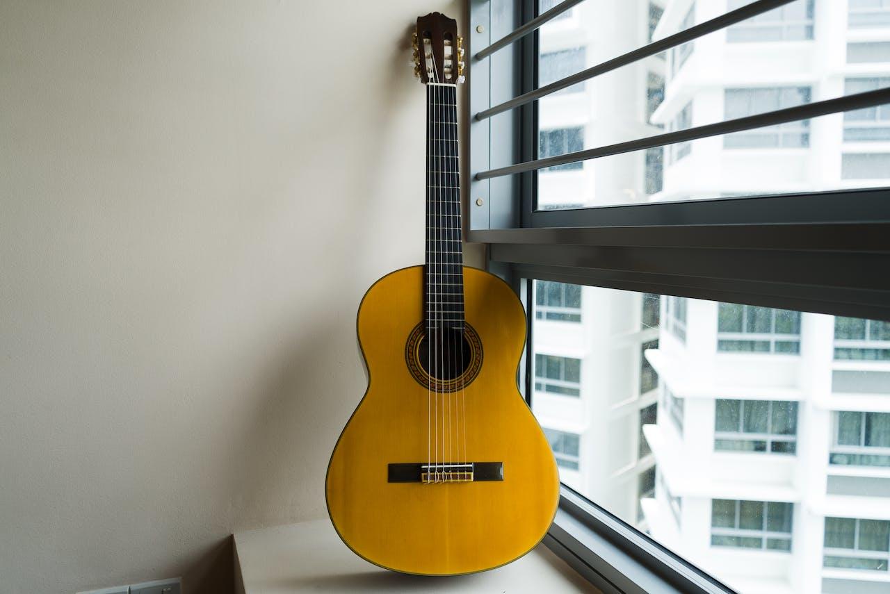 Guitarra criolla contra la ventana. 