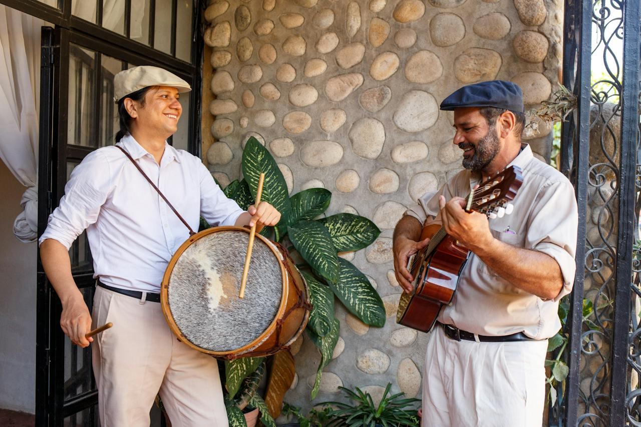 Dos personas tocando el bombo y la guitarra. 