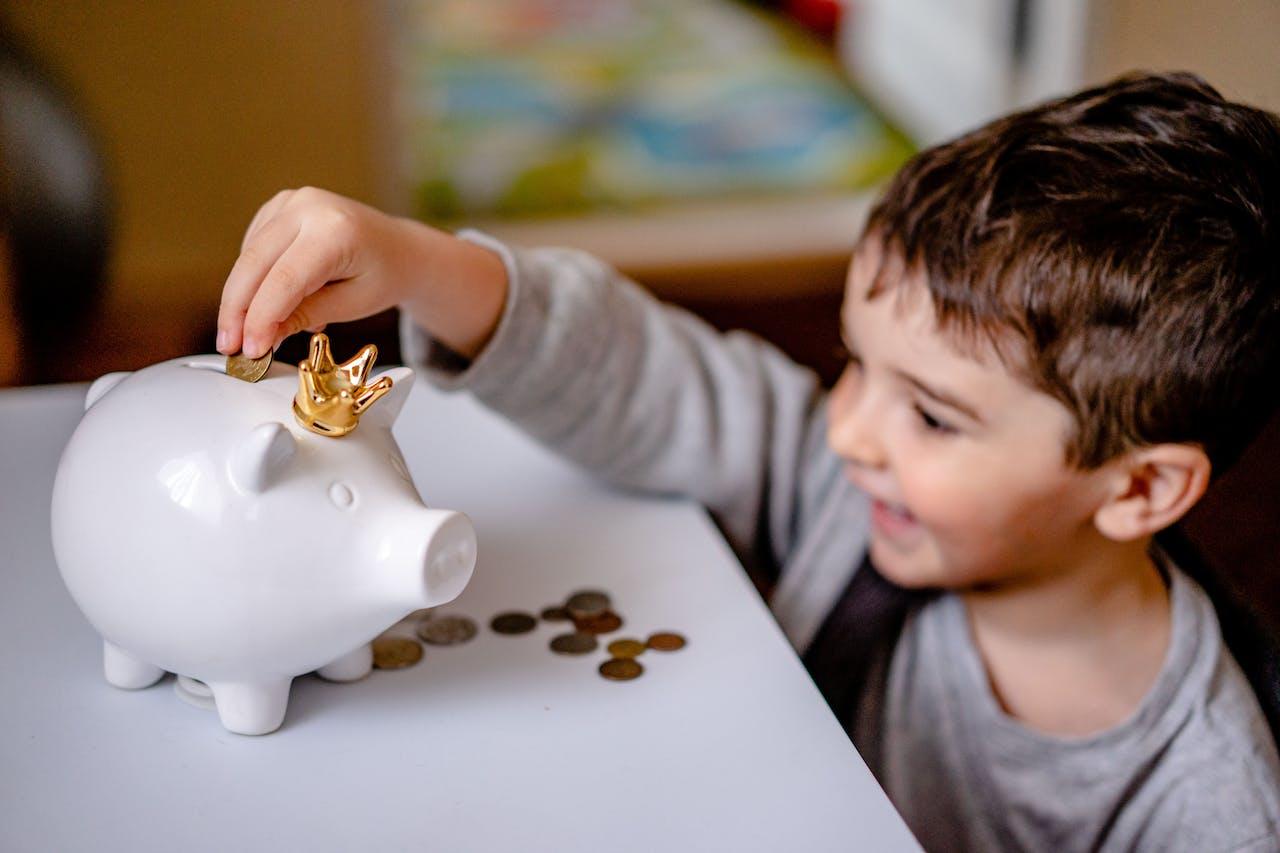 Niño guardando monedas en una alcancía