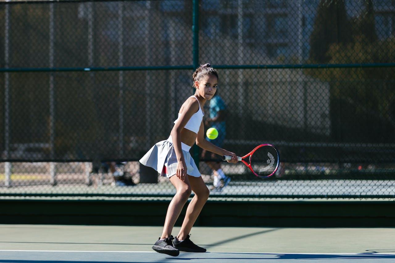 Niña jugando al tenis.