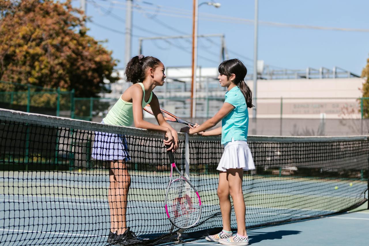 Dos niñas en una cancha de tenis. 