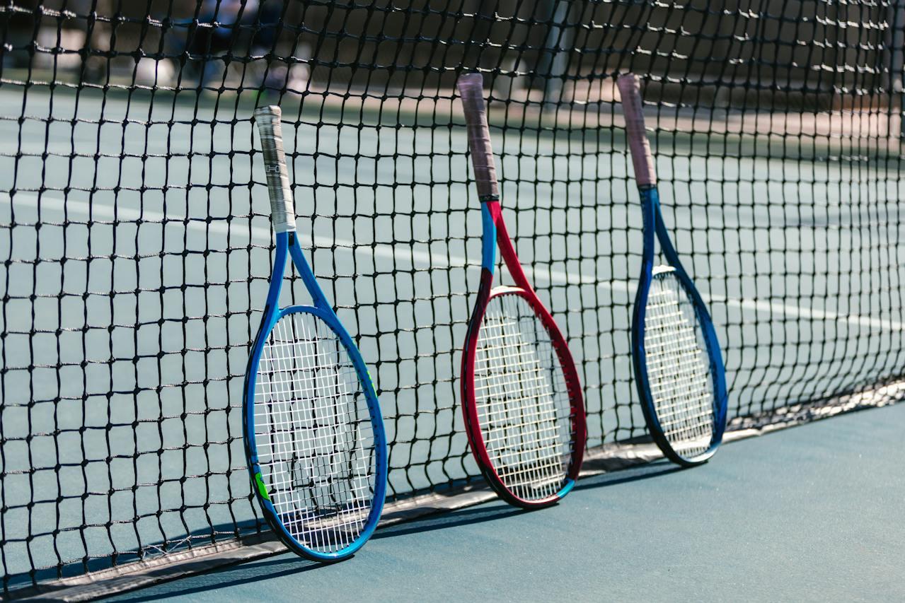 Raquetas de tenis apoyadas sobre la red.