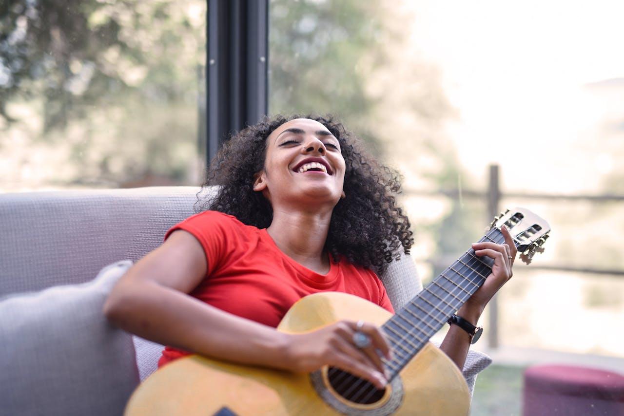 Mujer sonriente con una guitarra.