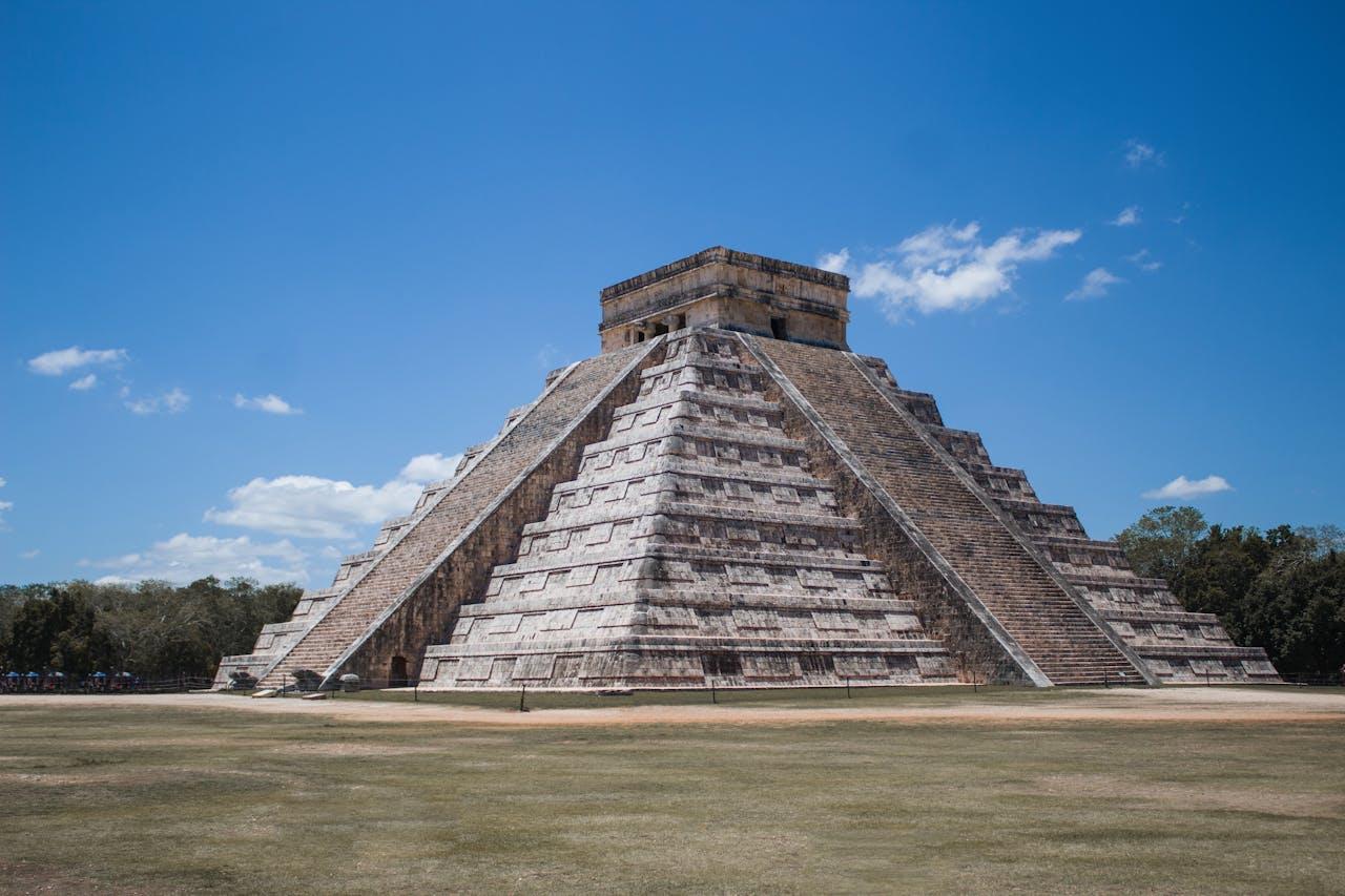 Pirámide de piedra sobre césped verde (Chichén Itzá, México)