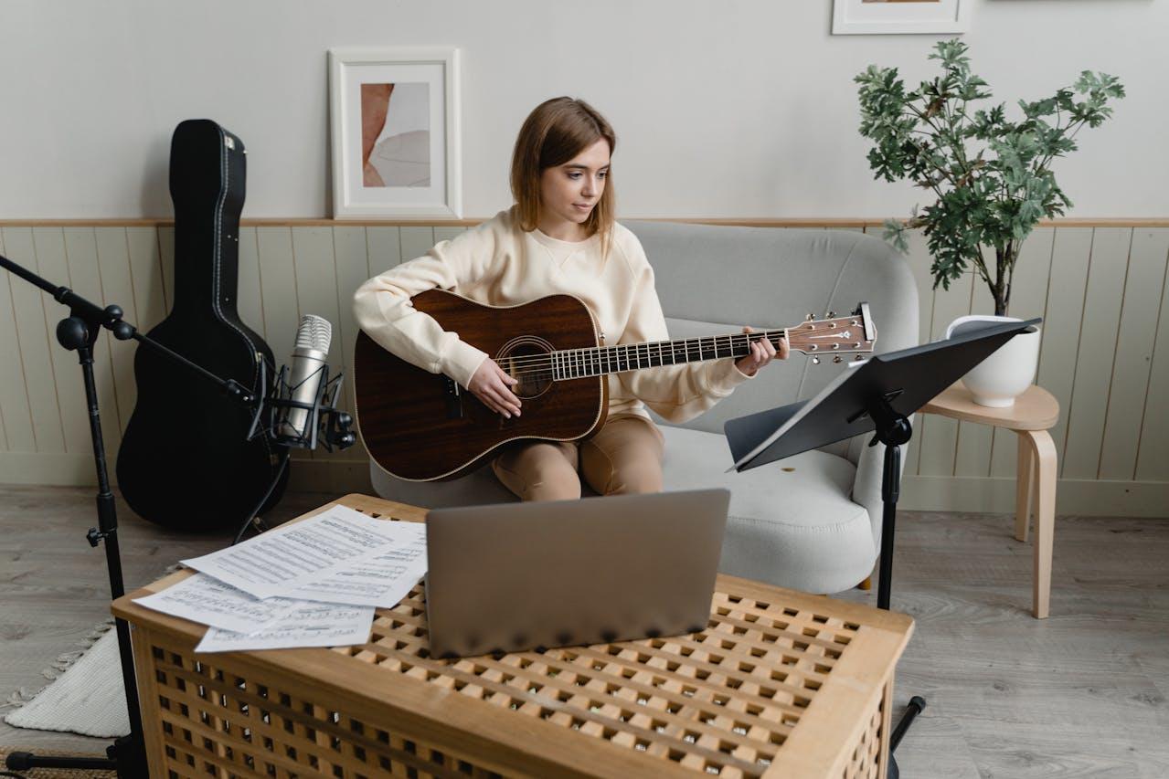 Mujer con guitarra sentada en el sillon.