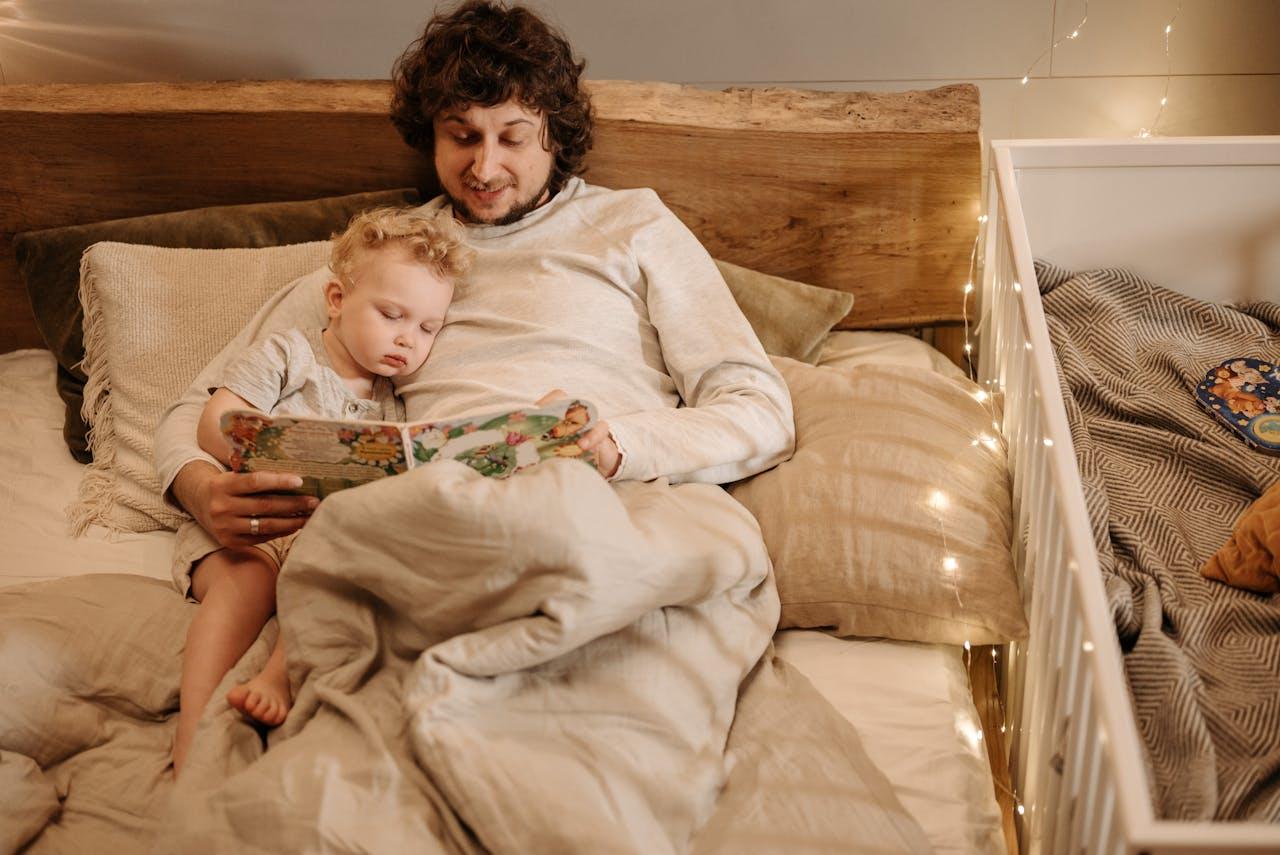 Niño y adulto leyendo en la cama