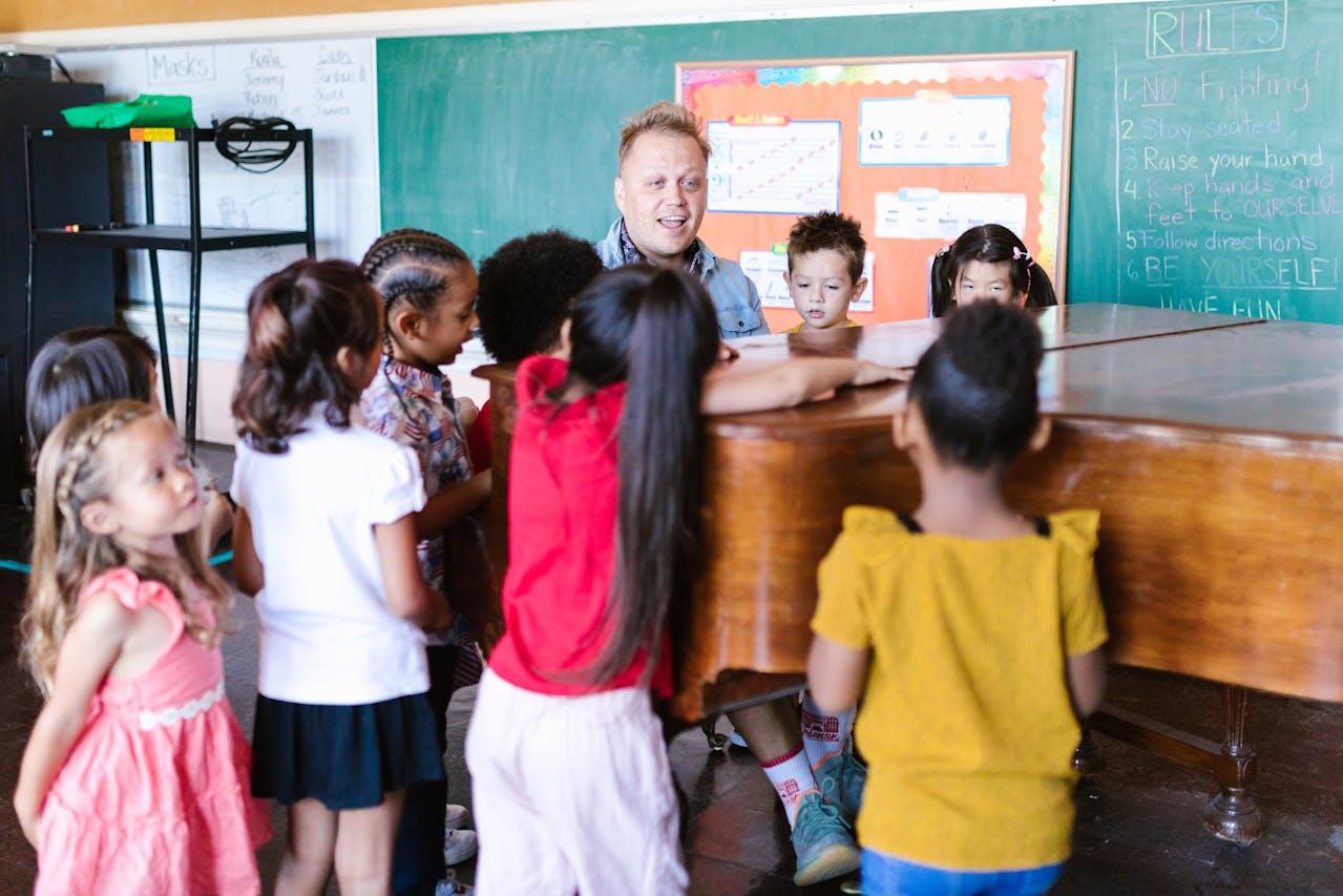 Niños y adulto alrededor de un piano.