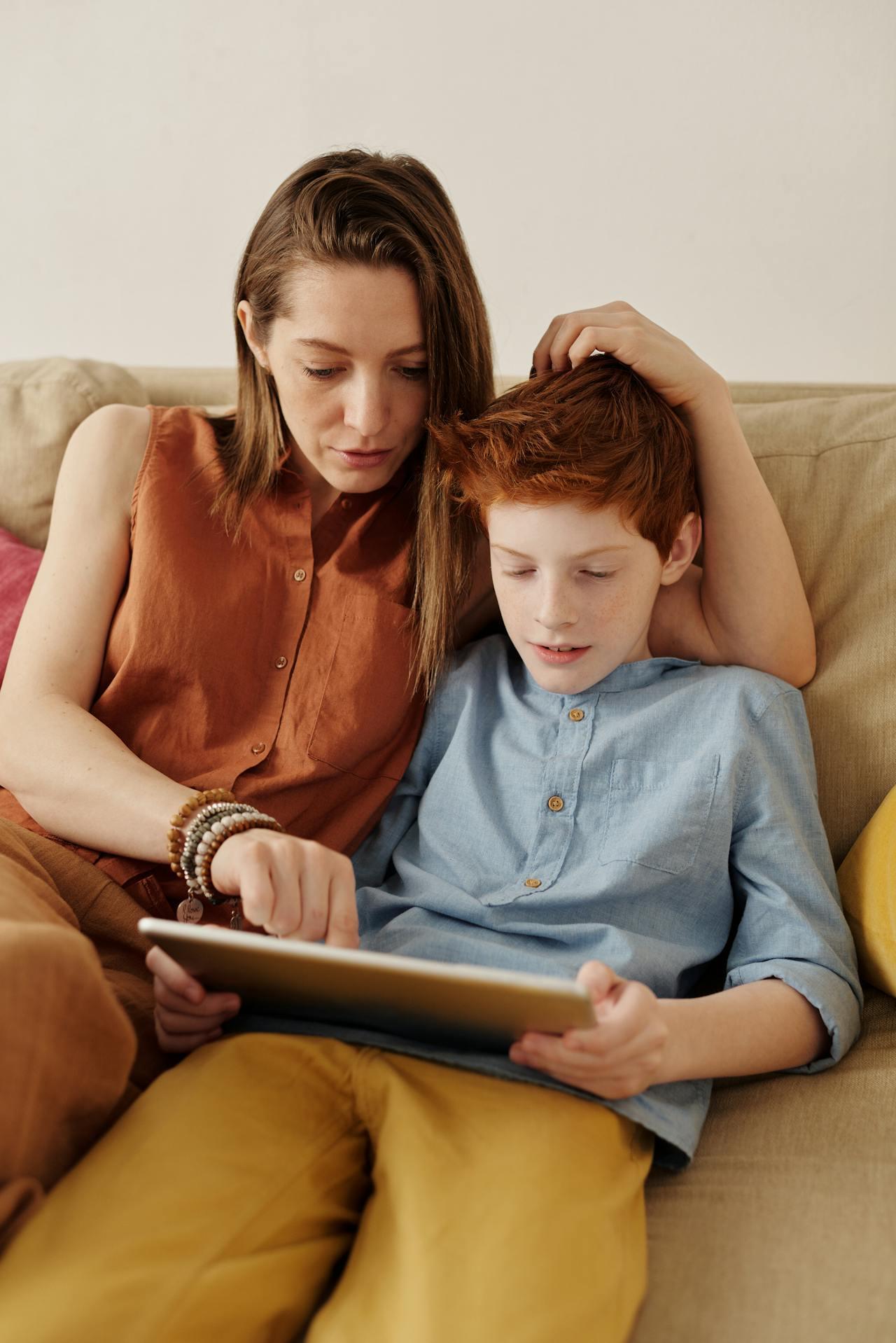 Mujer y niño leyendo en el sillón.