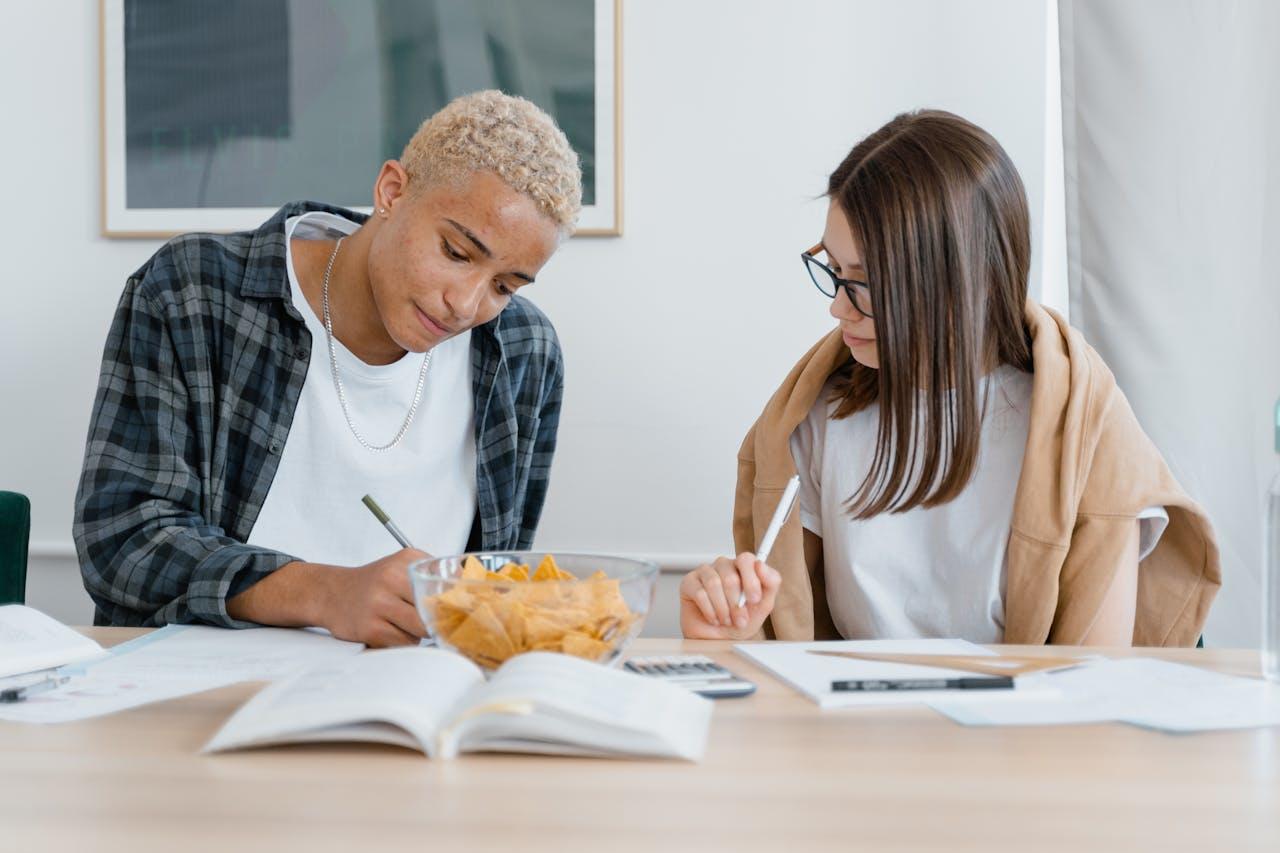 Un hombre y una mujer estudiando en la mesa.