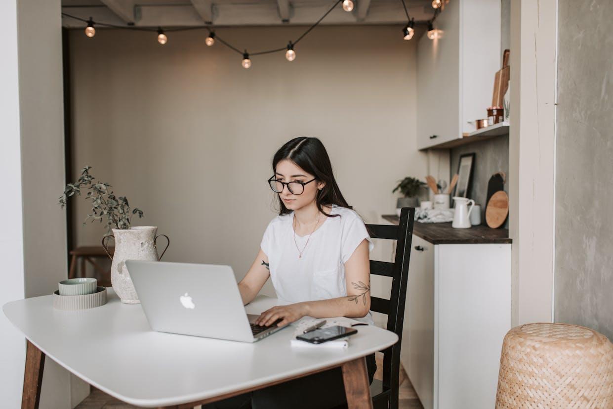Mujer sentada en la mesa frente a la computadora.